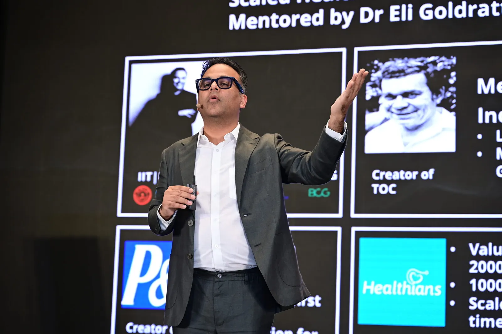 Anuj on stage with Dr Eli Goldratt, P&G, Healthians credibility wall
